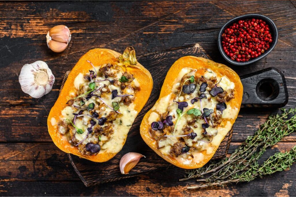 Calabaza o zapallo partido por la mitad, relleno de quinoa, champiñones y queso gratinado